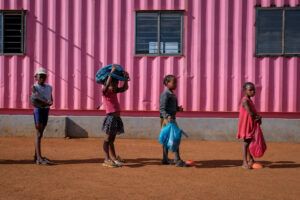 children lining up waiting to get a hot meal at the friday nightfeeding station with the winnie mabaso foundation